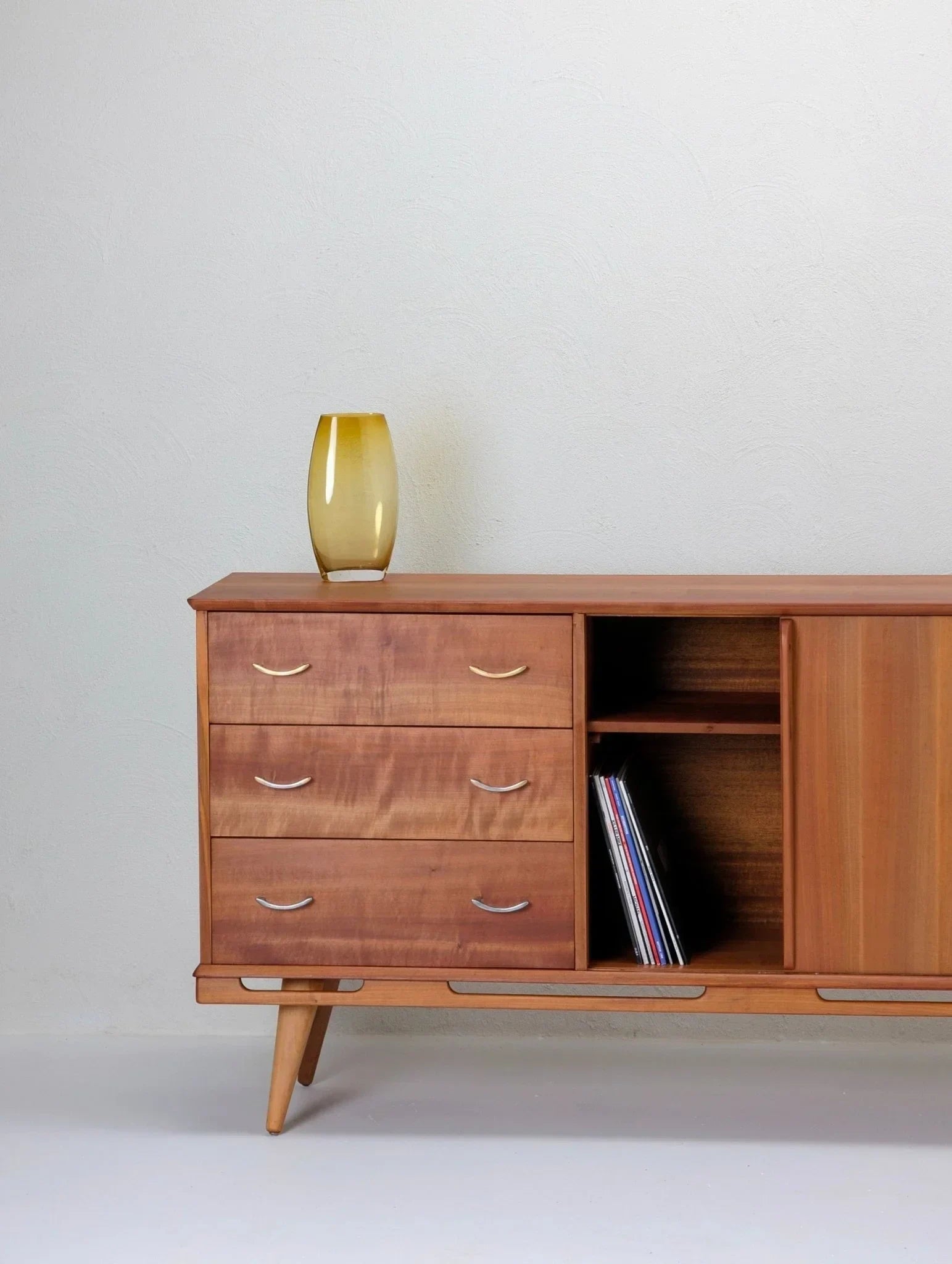 1950s Tasmanian myrtle sideboard with drawers, yellow vase, and vinyl records