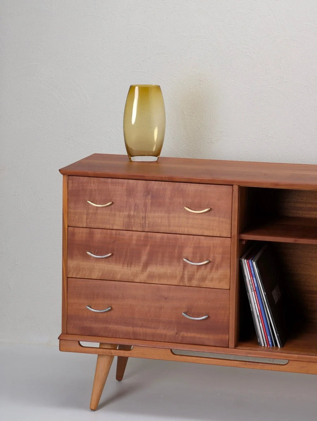 1950s Tasmanian myrtle wood sideboard with drawers, vinyl records, and glass vase