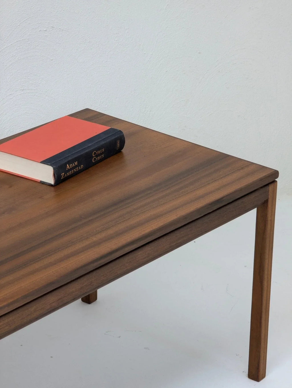 1960s vintage wood coffee table with book on top against white background