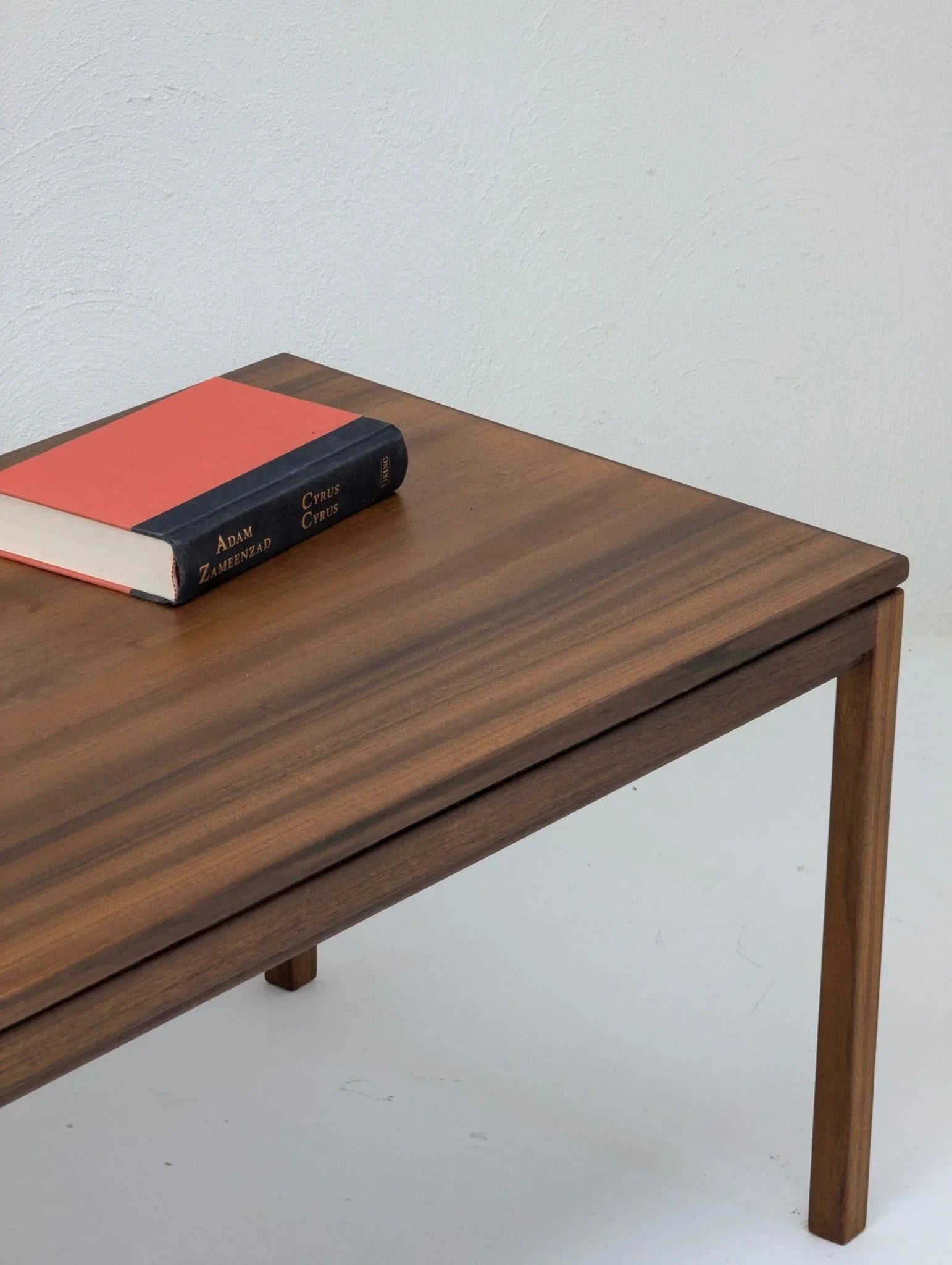 1960s vintage wood coffee table with book on top against white background