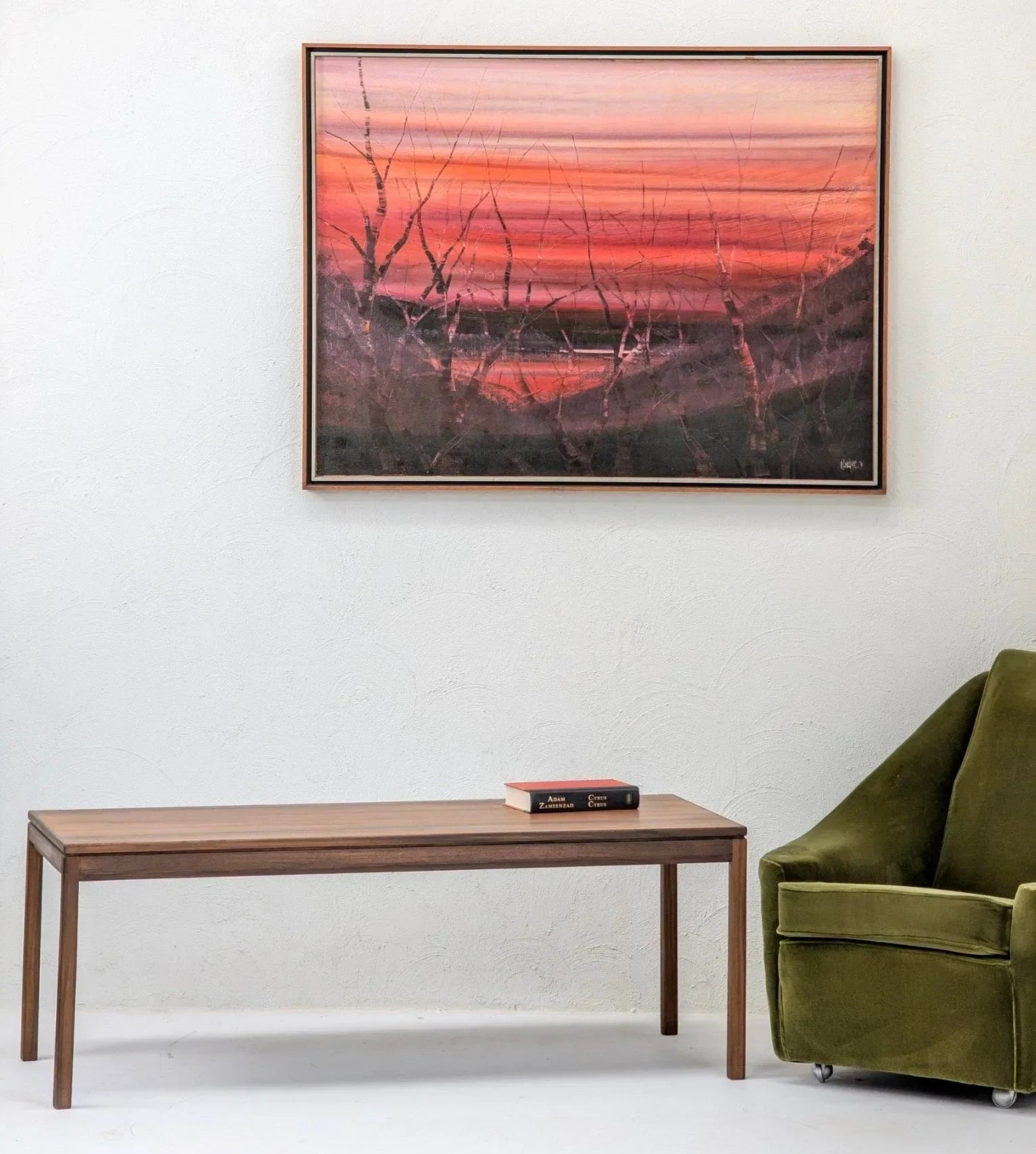 Mid-century modern William Latchford Sons coffee table in wood with book, paired with olive green velvet armchair and abstract wall art
