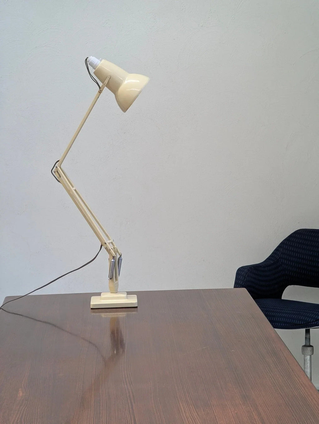 Vintage cream Herbert Terry Anglepoise desk lamp on wooden office table next to blue chair