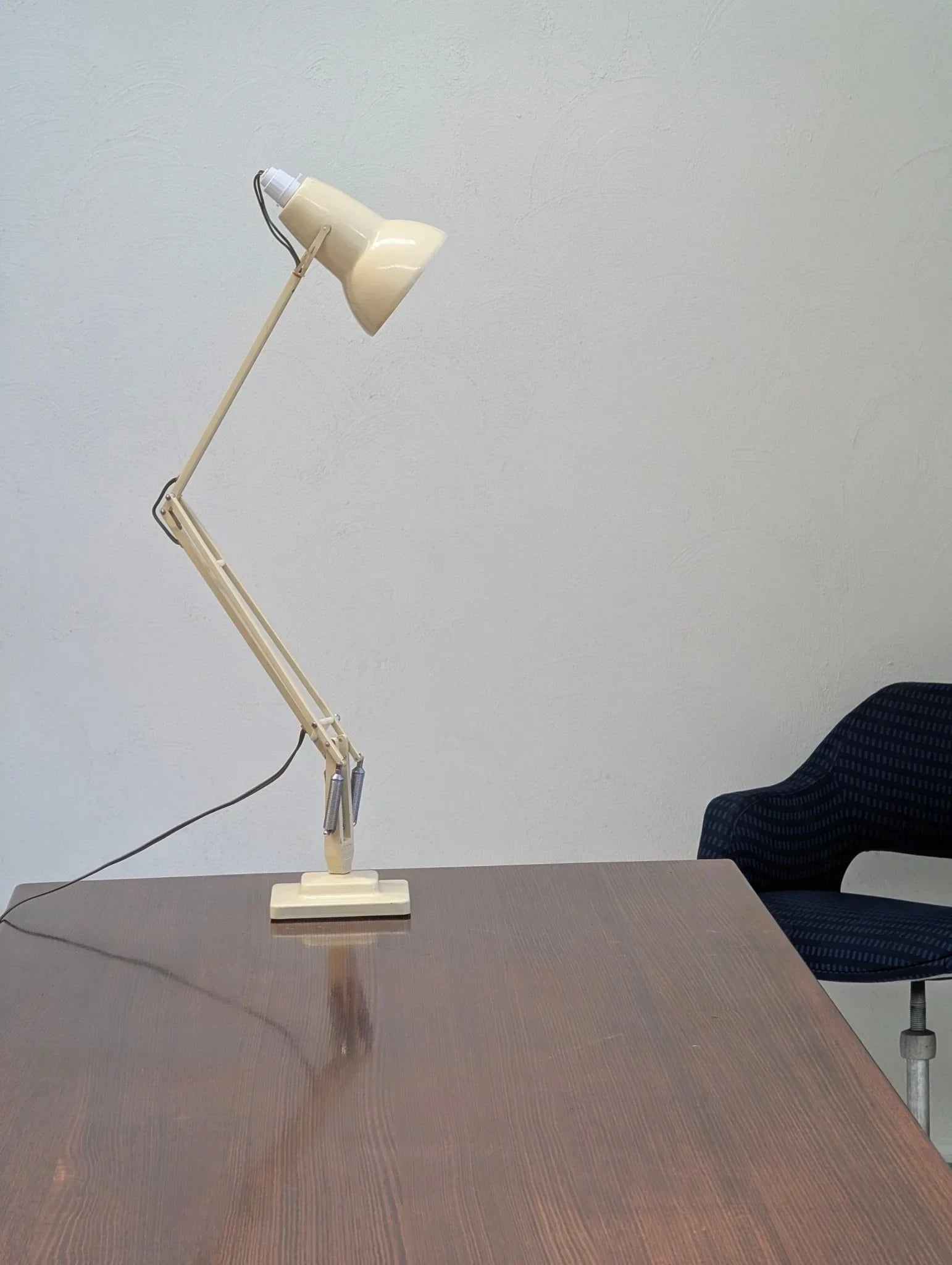 Vintage cream Herbert Terry Anglepoise desk lamp on wooden office table next to blue chair