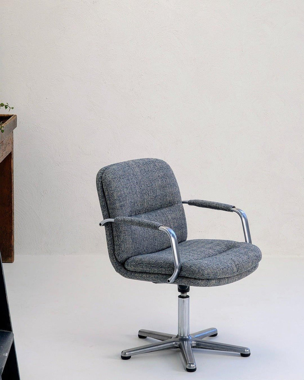 80s executive swivel armchair in textured grey wool with chrome frame on white background