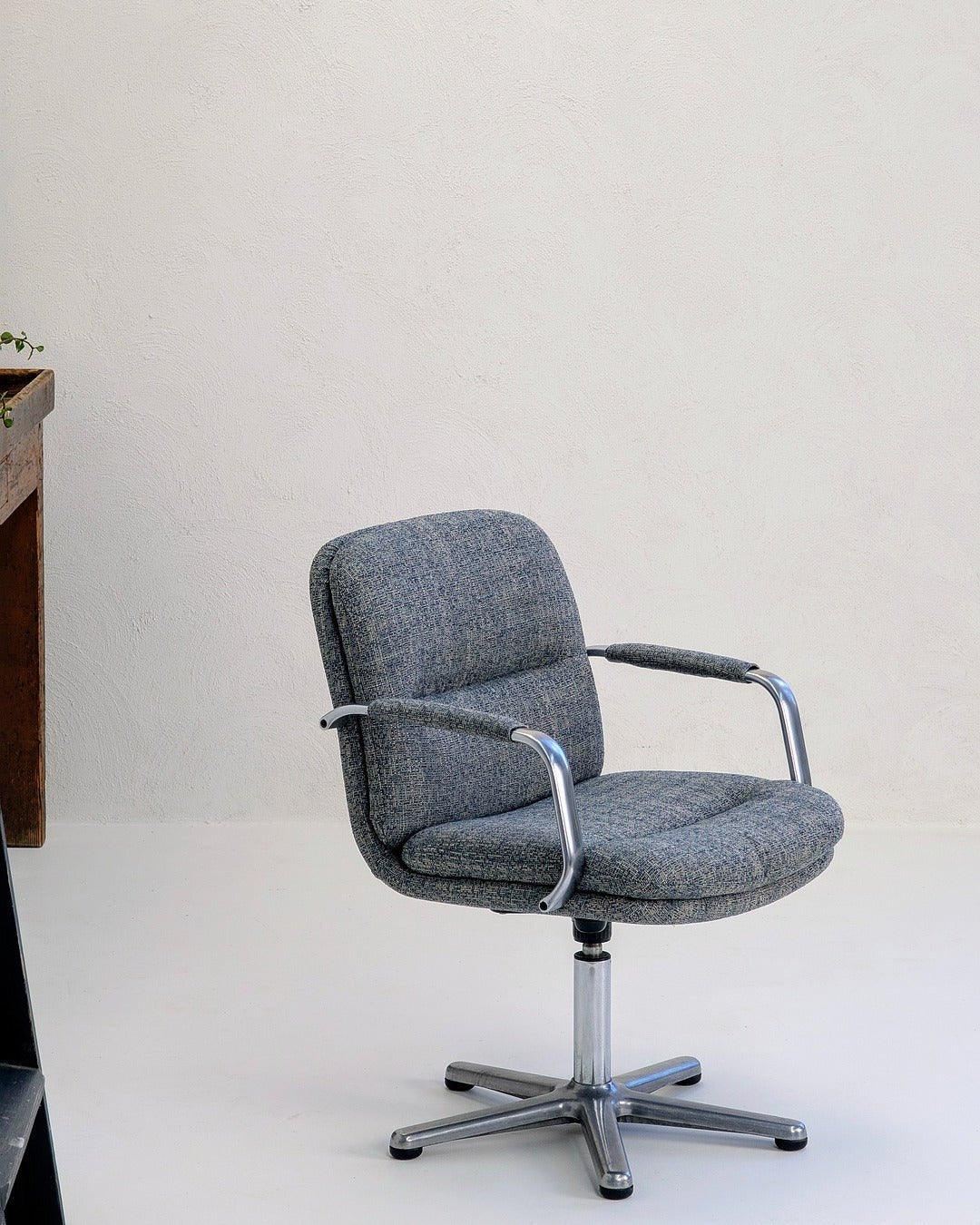 80s executive swivel armchair in textured grey wool with chrome frame on white background