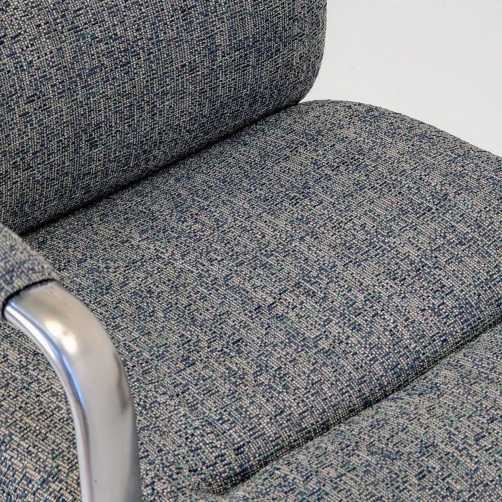 Close-up of 80s executive swivel armchair in textured wool with chrome armrest