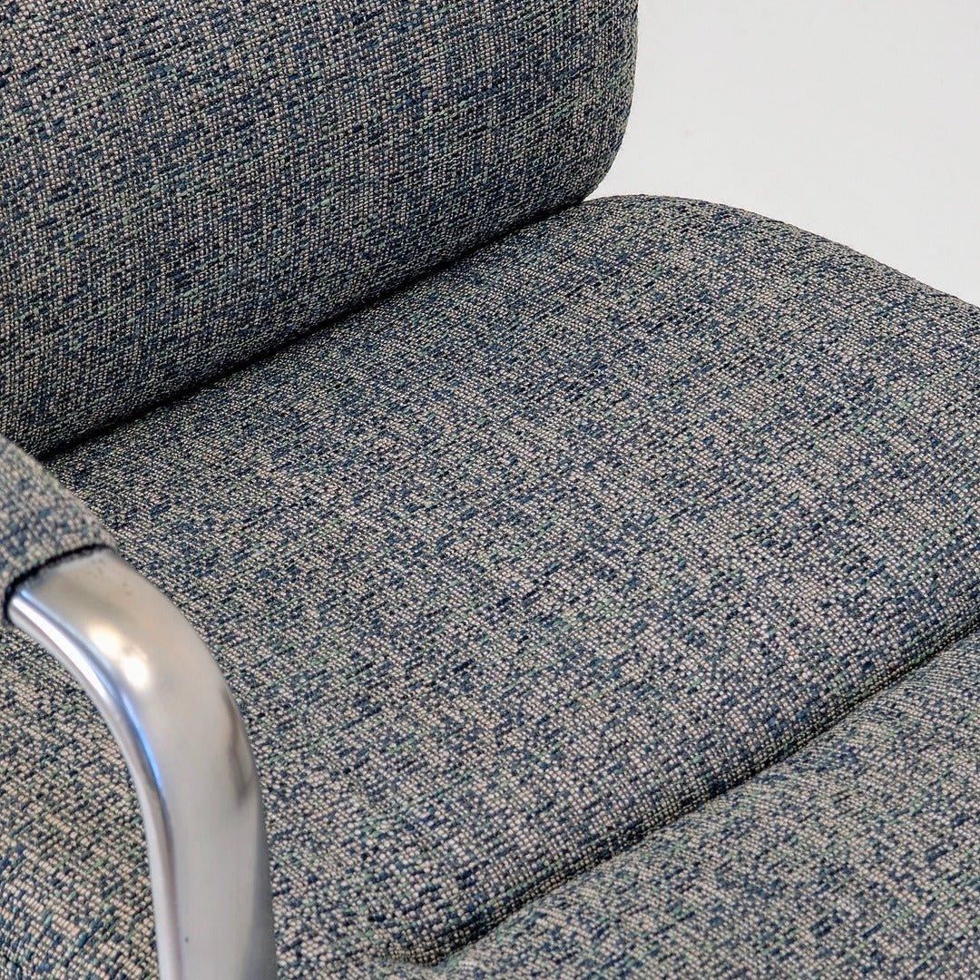 Close-up of 80s executive swivel armchair in textured wool with chrome armrest
