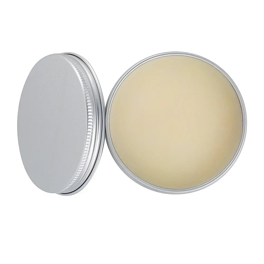 Round metal tin with lid, filled with solid cream balm on white background