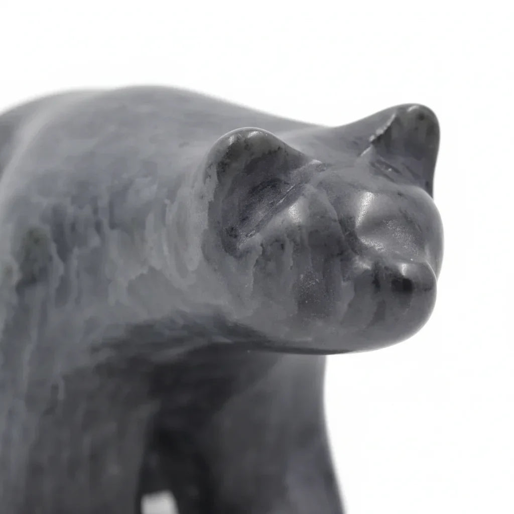 Polished black stone bear sculpture with smooth finish on white background