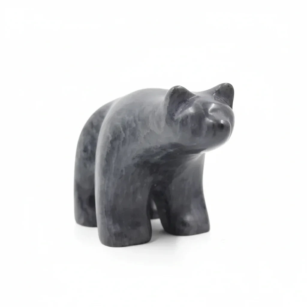 Polished black stone bear figurine on white background