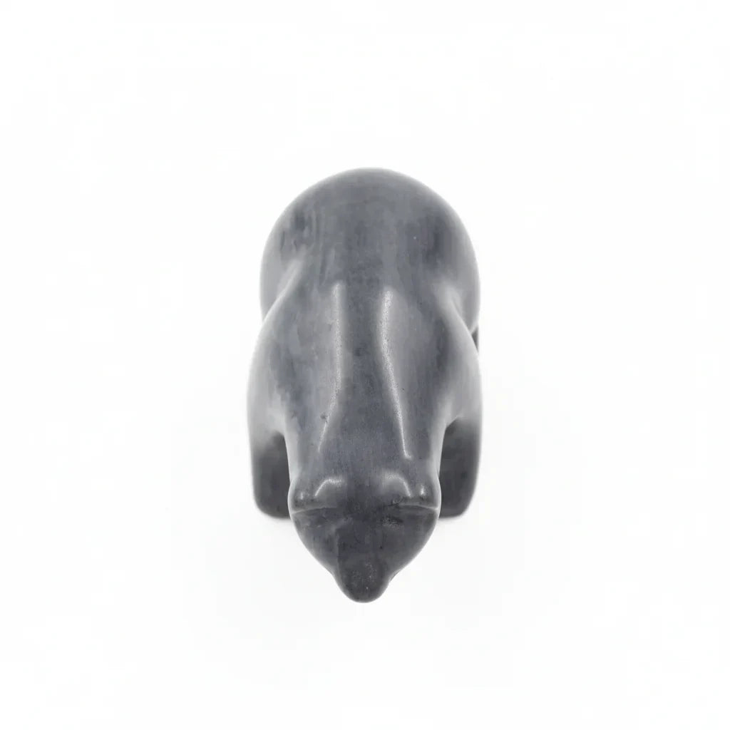 Top view of a black stone bear figurine on a white background