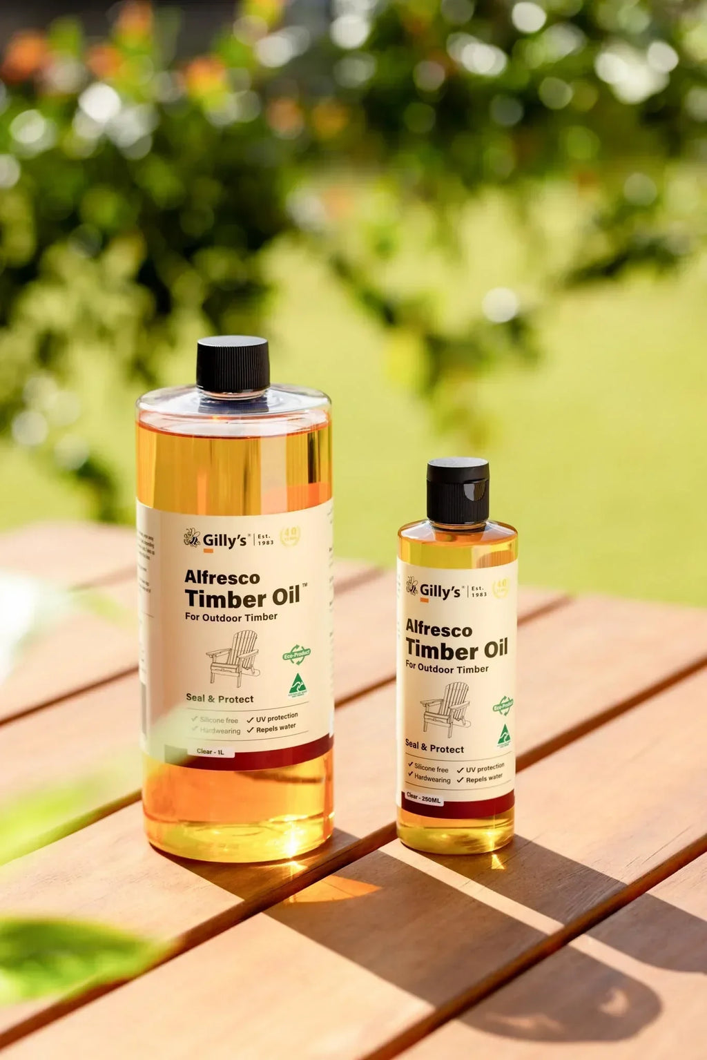 Gilly's Alfresco Timber Oil 1L and 250ml bottles on outdoor timber table in sunlight