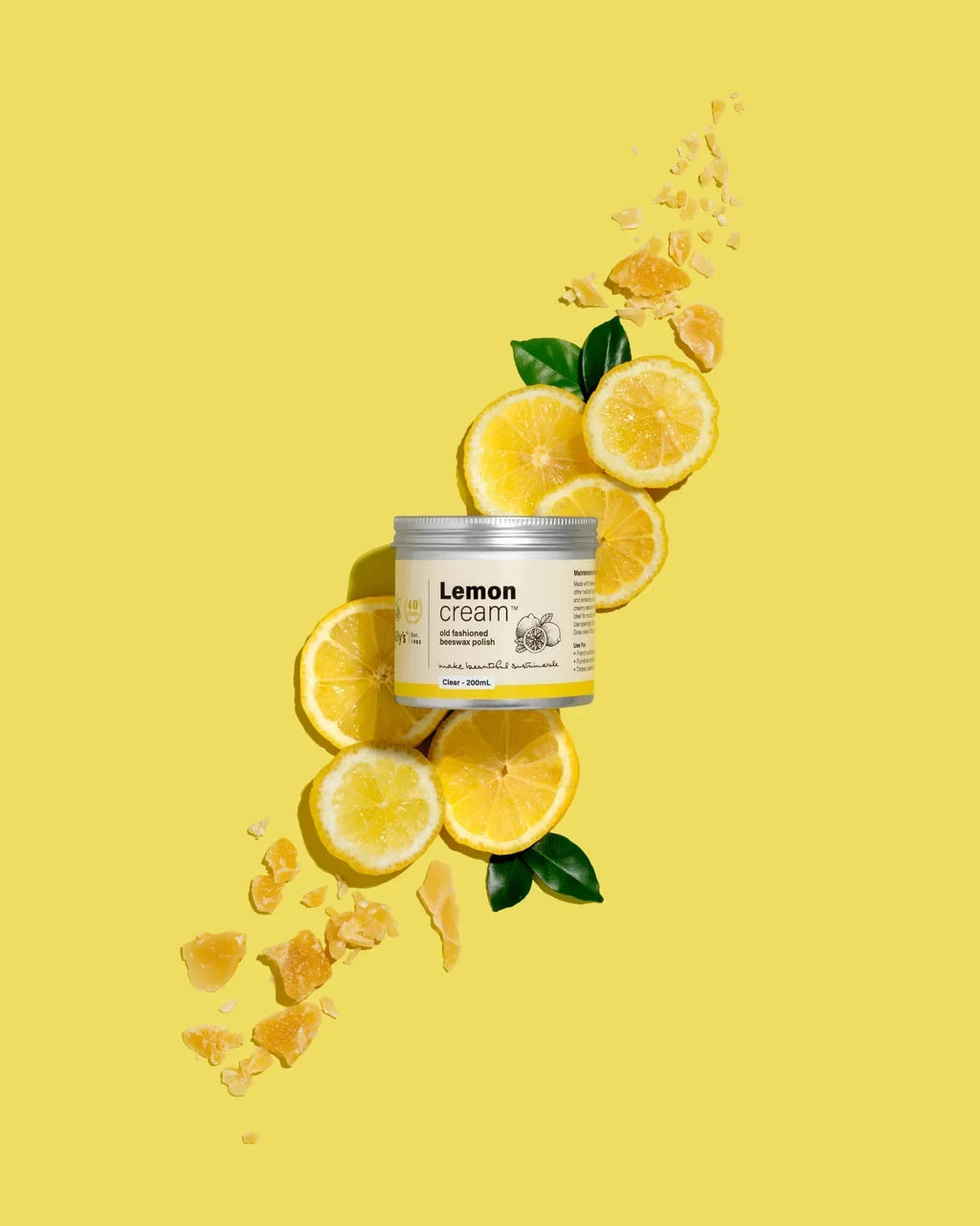 Gilly's Lemon Cream Polish 200ml jar with lemon slices and leaves on yellow background