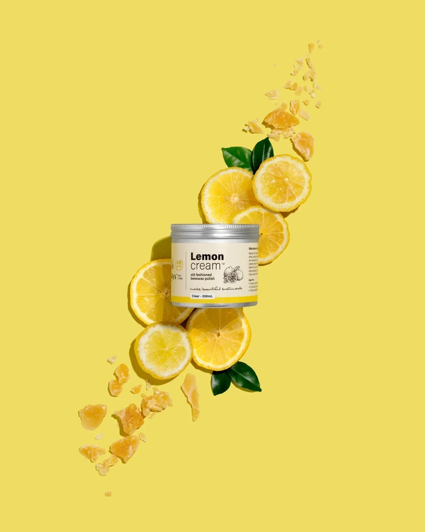 Gilly's Lemon Cream Polish 200ml jar with lemon slices and leaves on yellow background