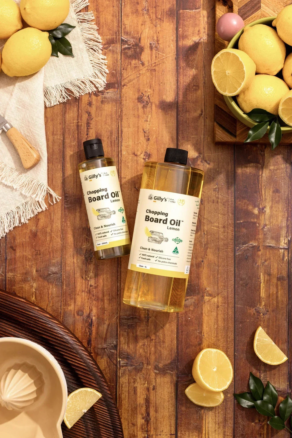 Gilly's Lemon chopping board oil bottles with fresh lemons on wooden table