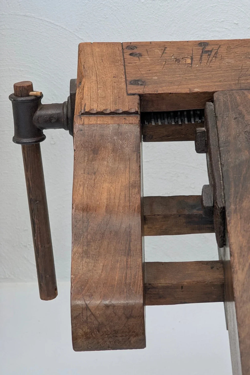 Close-up of antique wooden woodworking vise with metal screw and handle detail