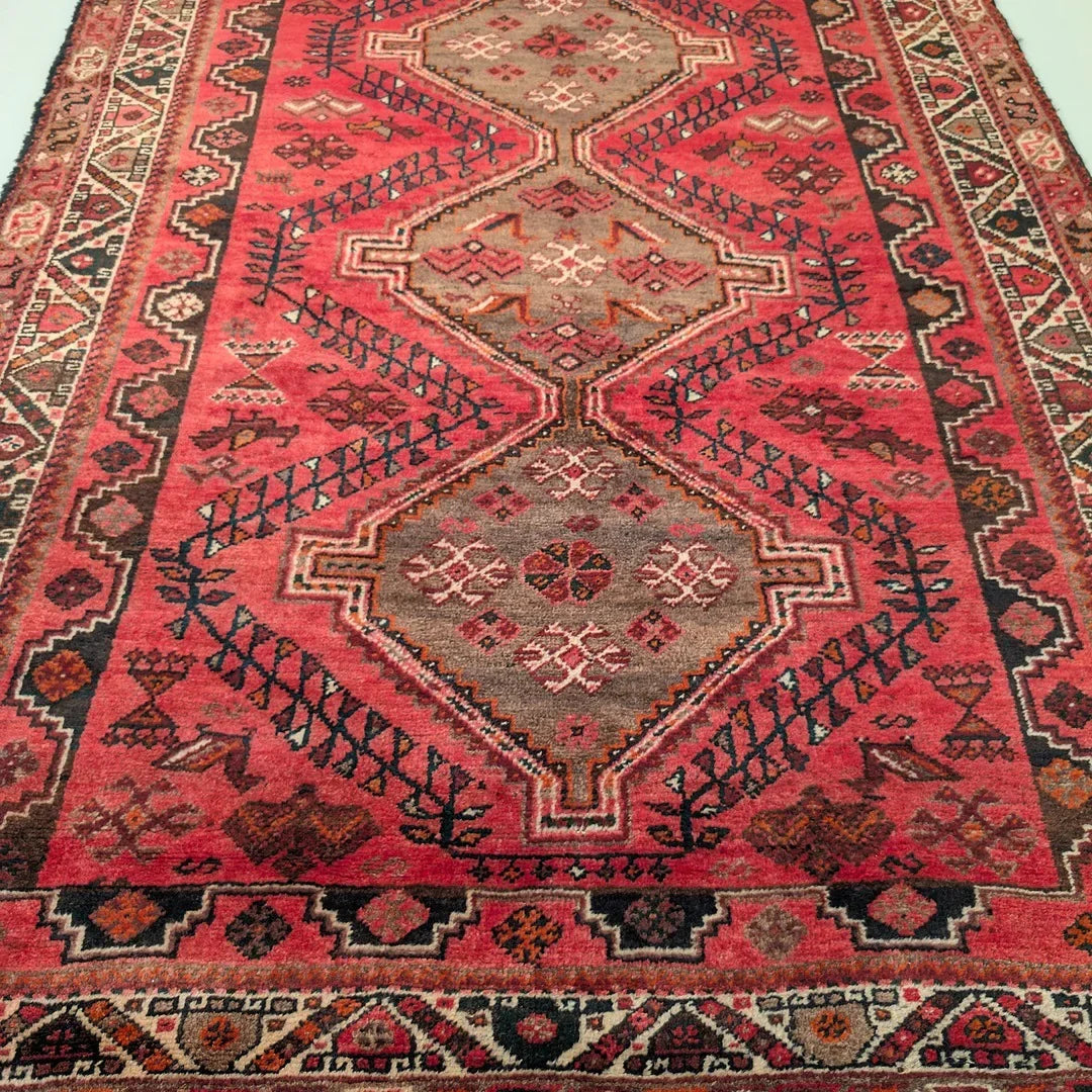 Vintage Persian rug with geometric patterns in red, brown, and black