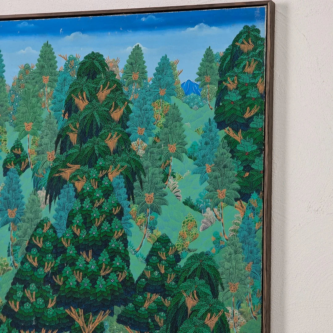 Framed detailed forest painting with lush green trees and a blue sky displayed on a white wall