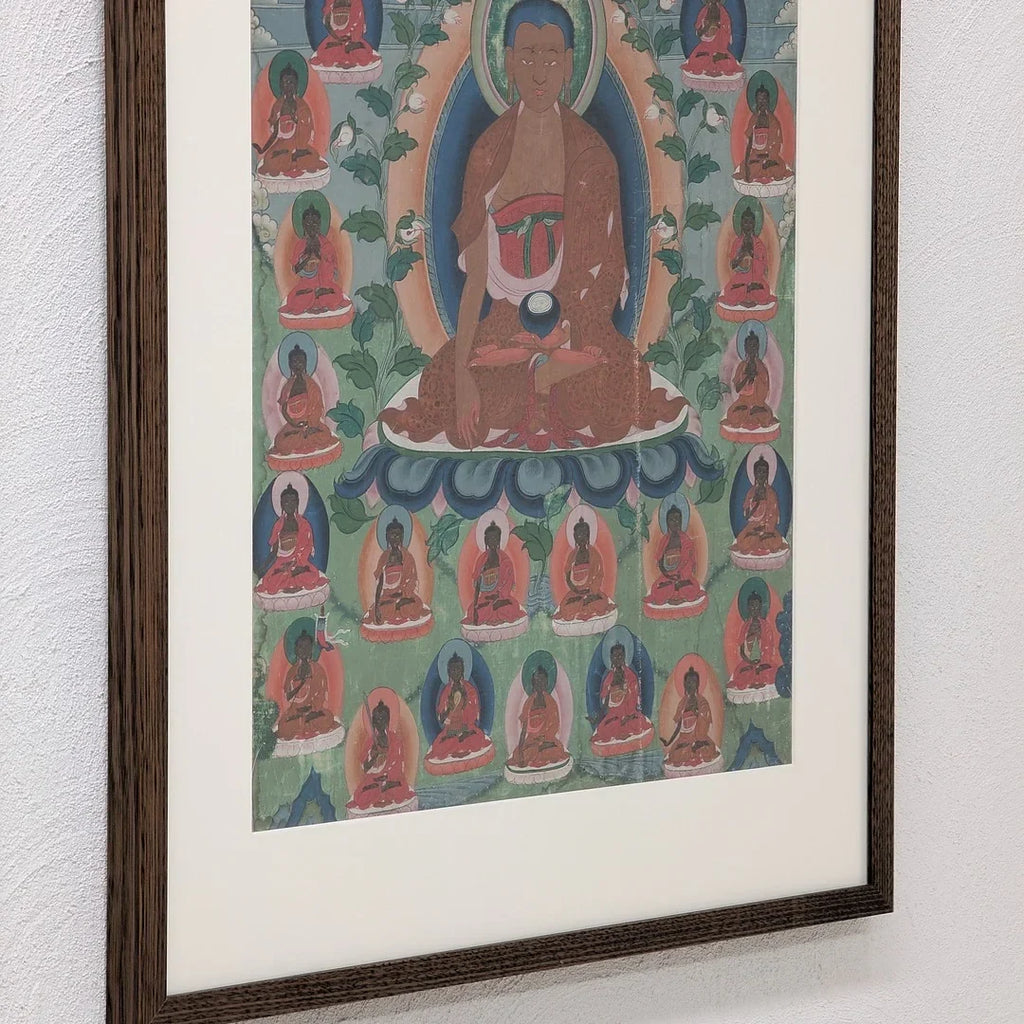 Framed Tibetan thangka painting with central Buddha figure and multiple smaller Buddhas