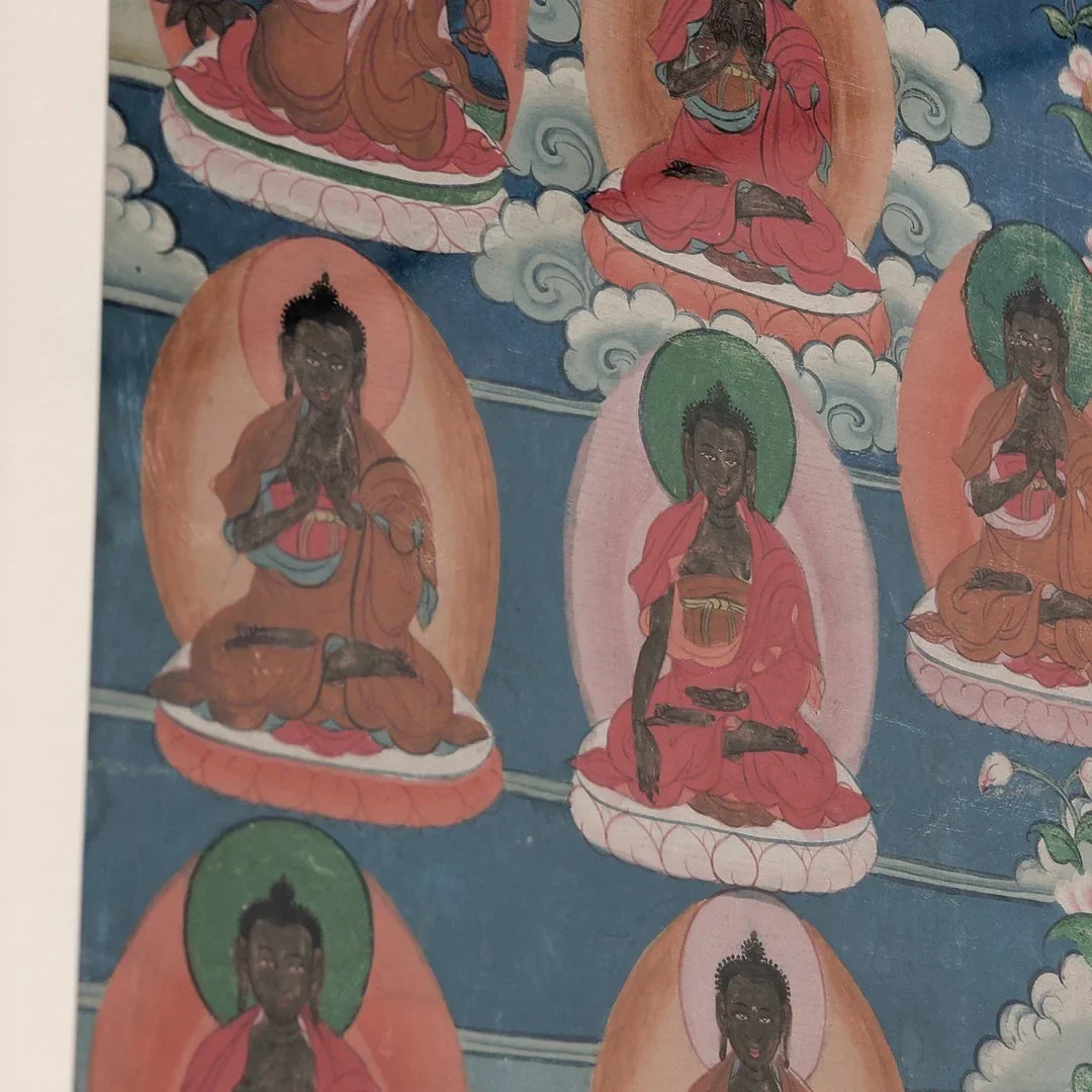 Traditional Buddhist thangka painting with seated Buddhas on lotus thrones and cloud motifs