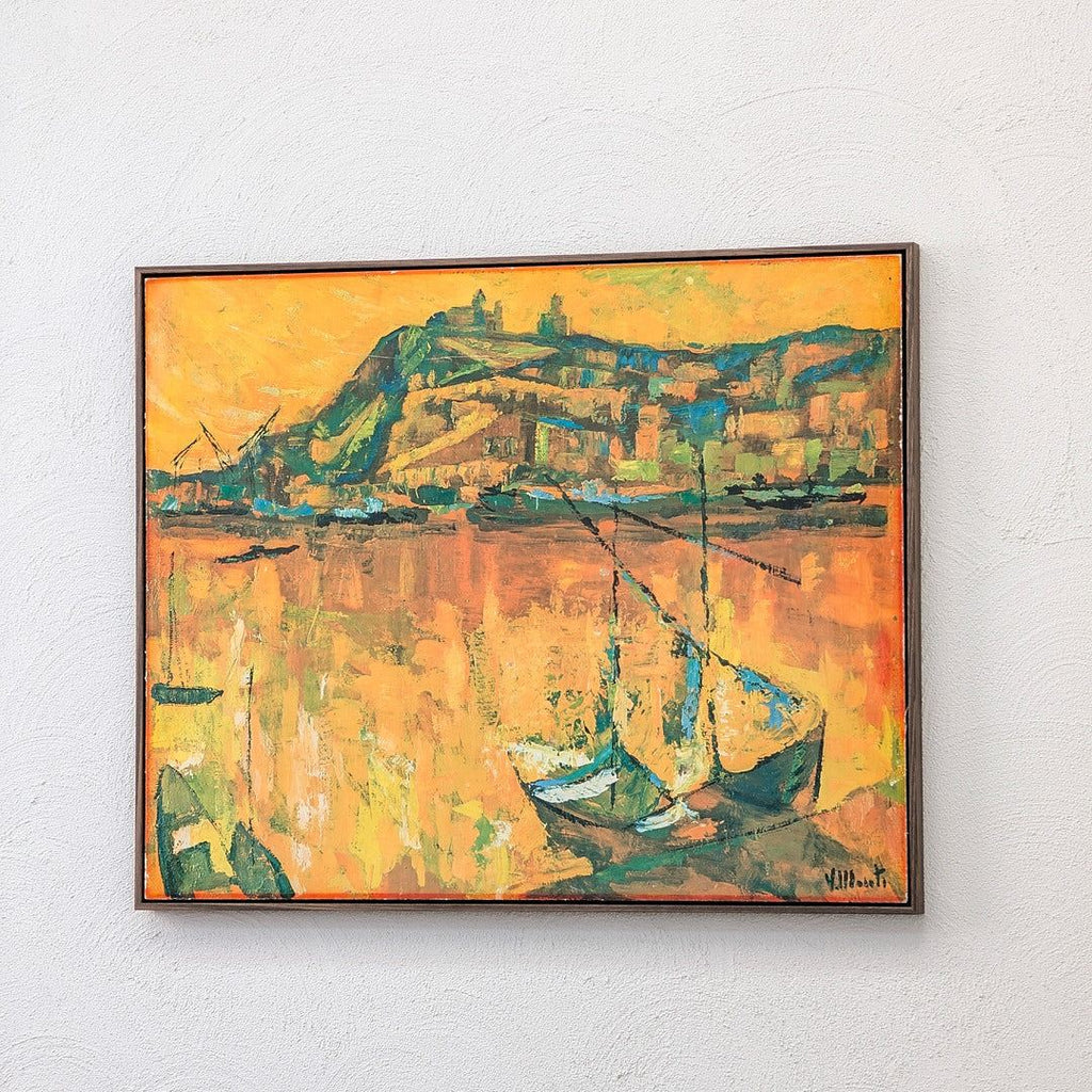 Framed impressionist painting of boats docked by a harbor with a vibrant orange and yellow sky
