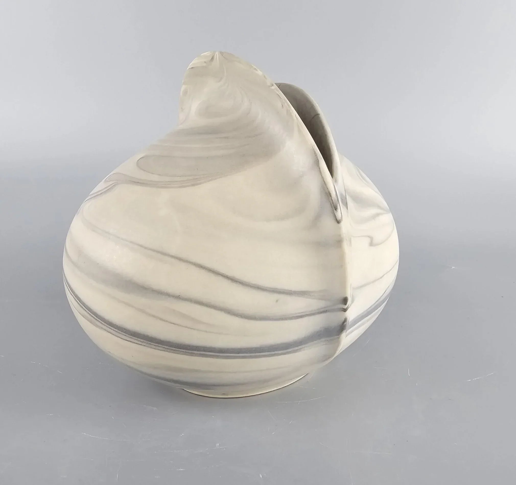 Modern marbled ceramic vase with abstract round shape on gray background