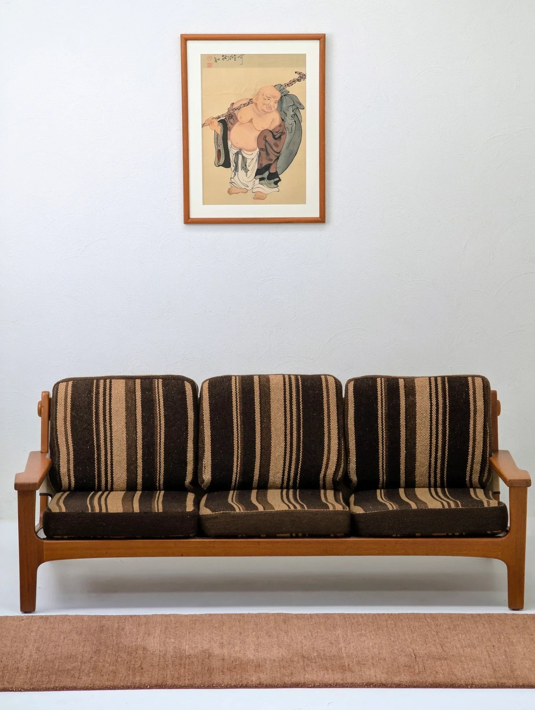 Mid-century modern striped brown sofa with wall art above in minimalist living room