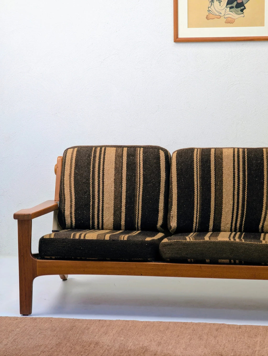 Mid-century modern sofa with brown and black striped cushions in a minimalist living room