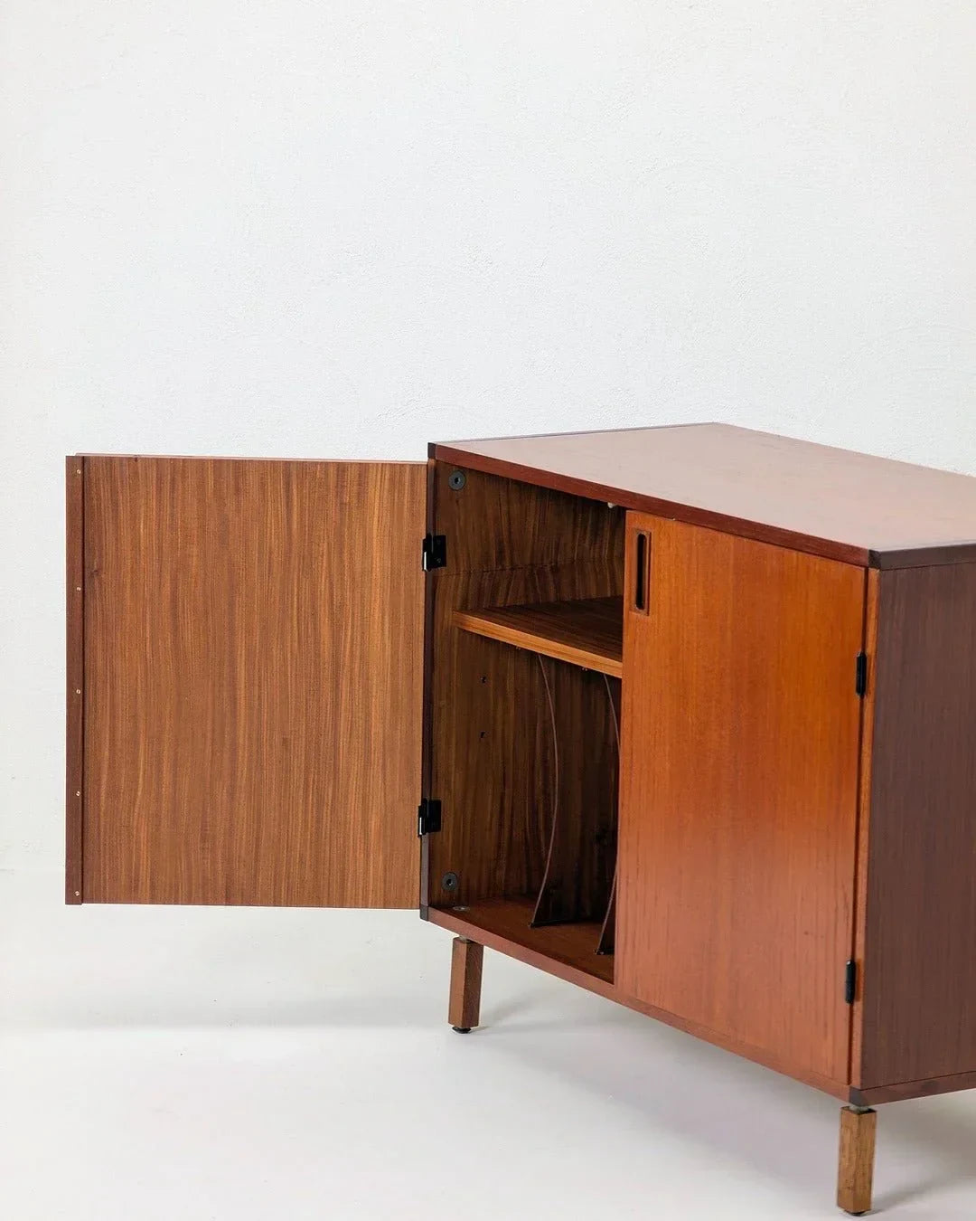 1970s Danish teak LP vinyl cabinet with open door and interior shelving on white background