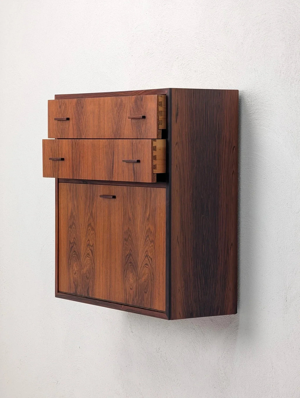 Danish modern floating rosewood cabinet with drawers, 1960s, on white wall