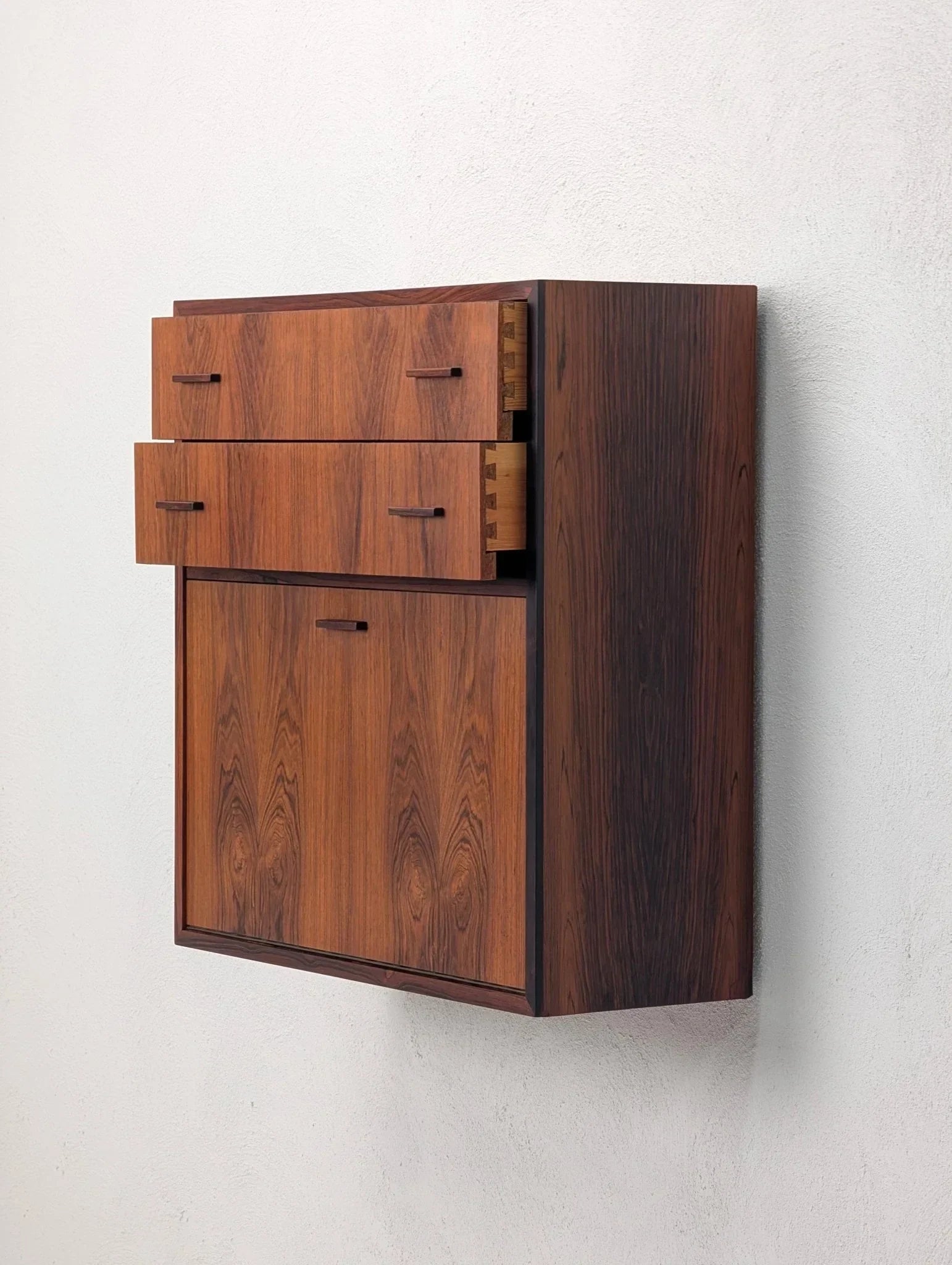 Danish modern floating rosewood cabinet with drawers, 1960s, on white wall