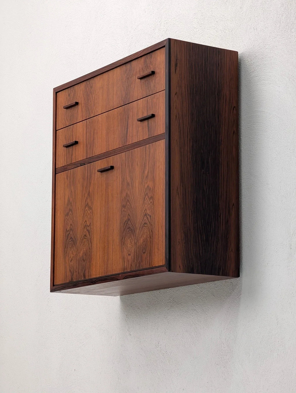 Danish modern floating cabinet in book-matched rosewood mounted on a white wall