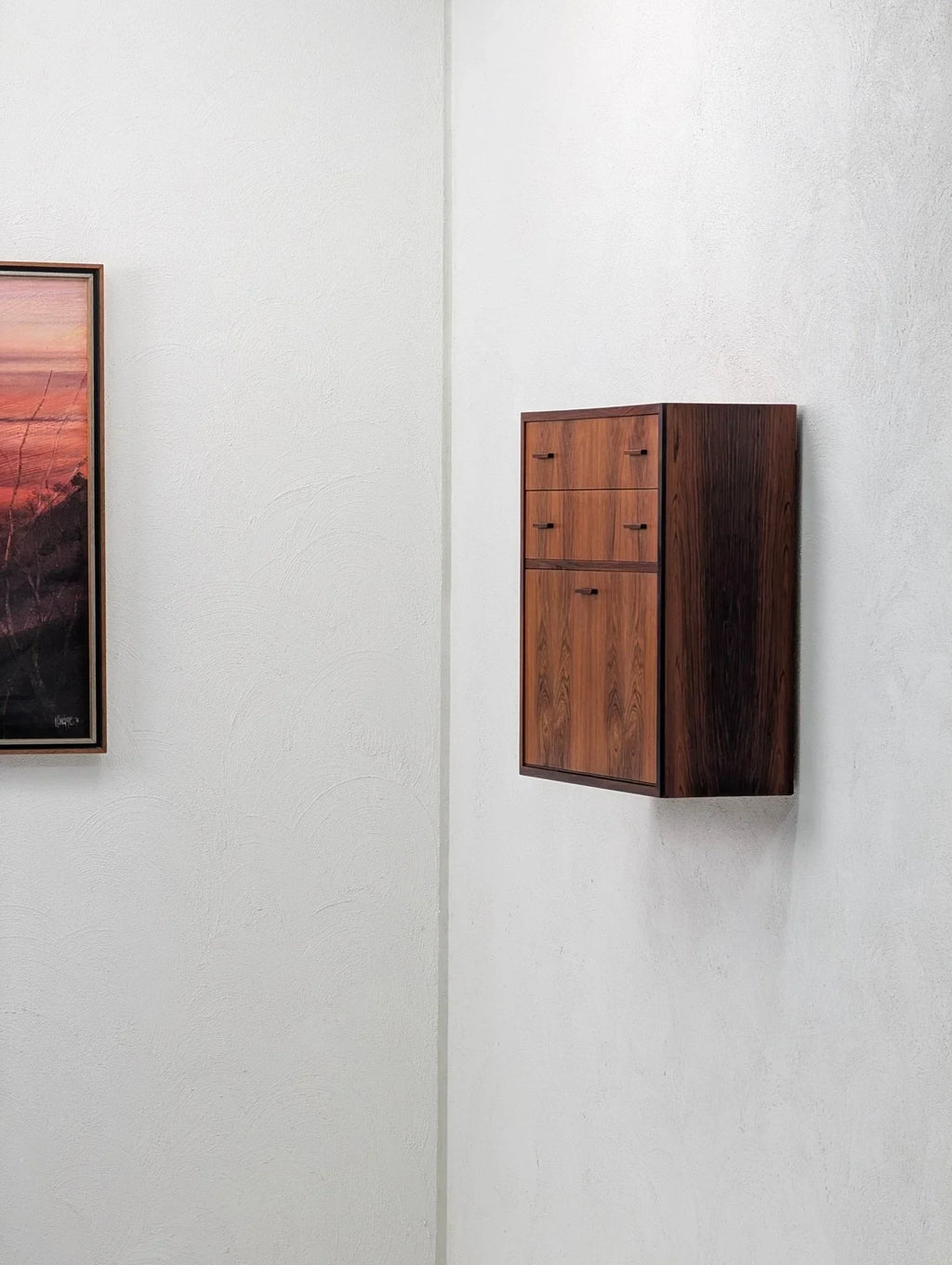 Danish modern floating cabinet in book-matched rosewood mounted on a white wall