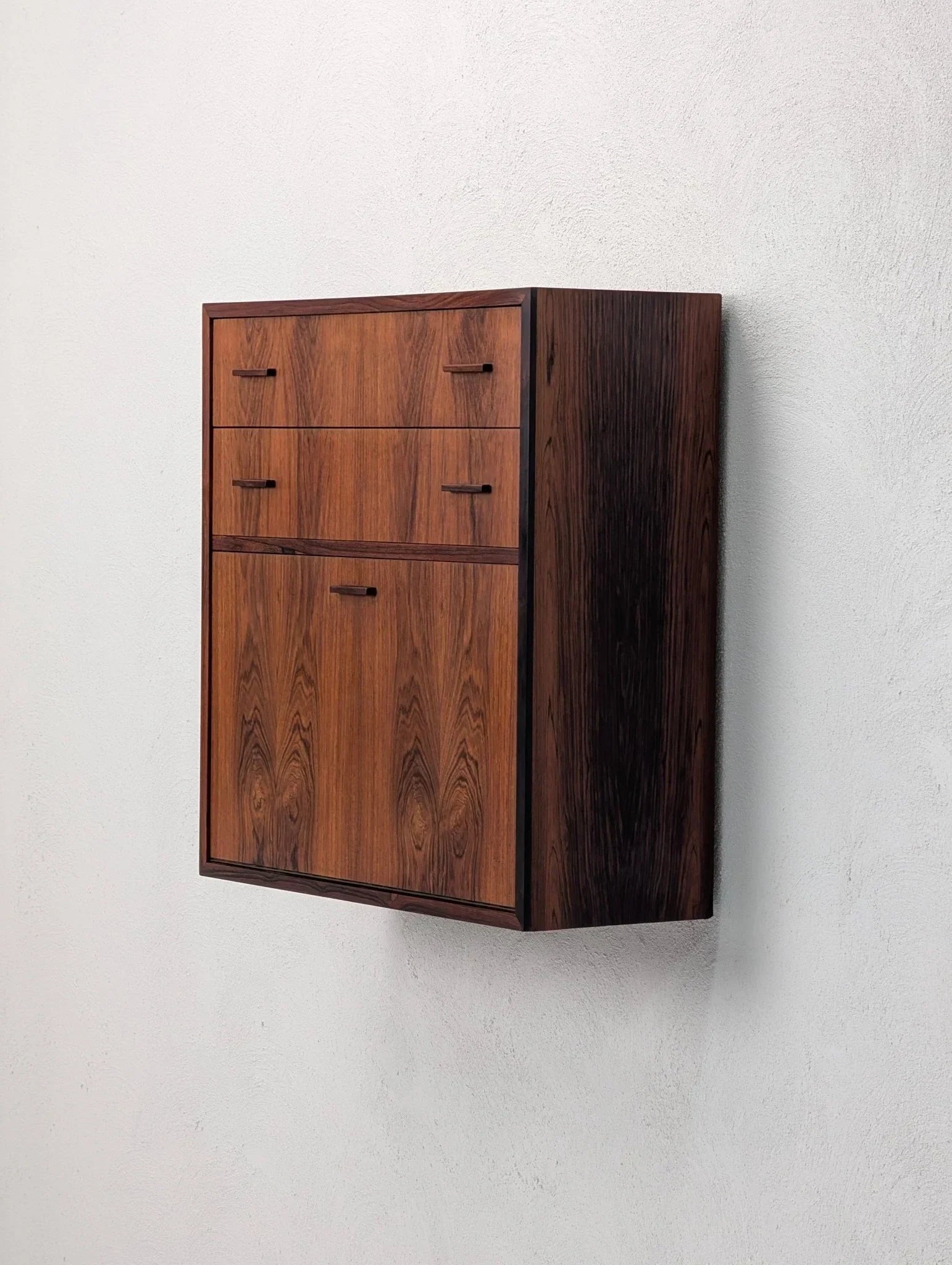 Danish modern floating rosewood cabinet with book-matched grain mounted on white wall