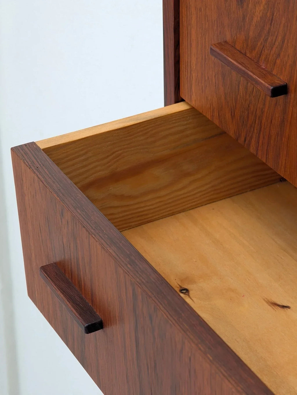 Open drawer of Danish modern floating rosewood cabinet with wood grain detail, 1960s style