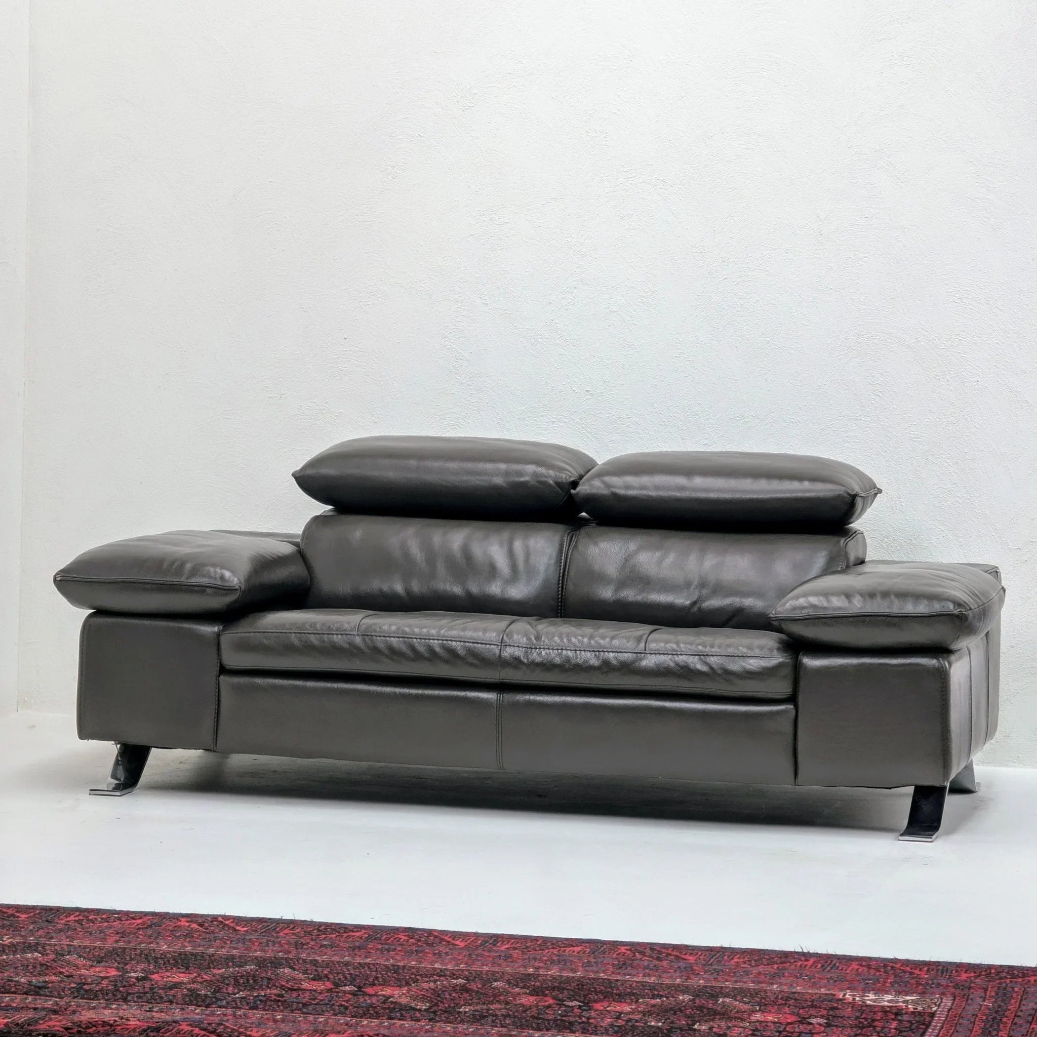 Domicil Butterfly modern leather sofa with adjustable headrests in a minimalist room