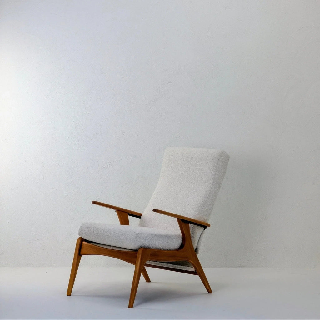 Creamy white boucle armchair with wooden frame in minimalist setting