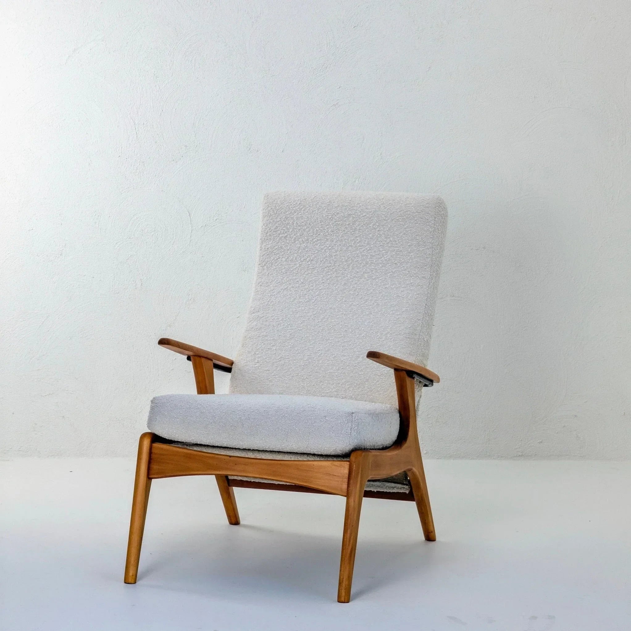 E32 armchair in creamy white boucle upholstery with wooden frame on white background