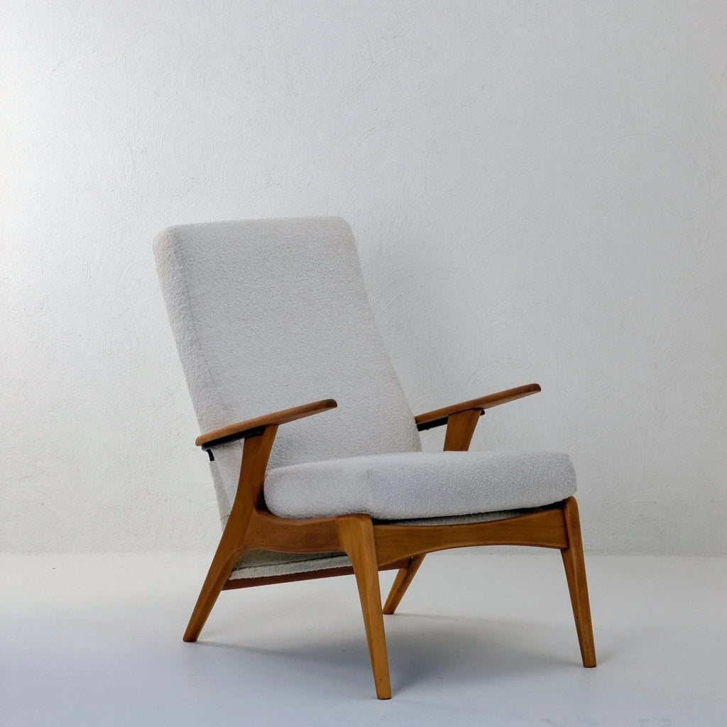 Creamy white boucle armchair with wooden frame in a minimal modern room