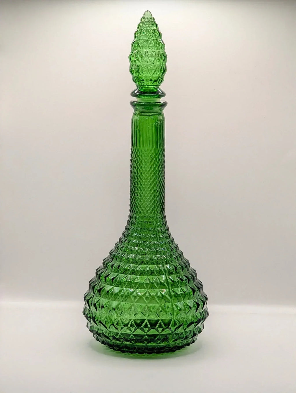 Green mid-century Italian Empoli diamond point genie bottle decanter on white background