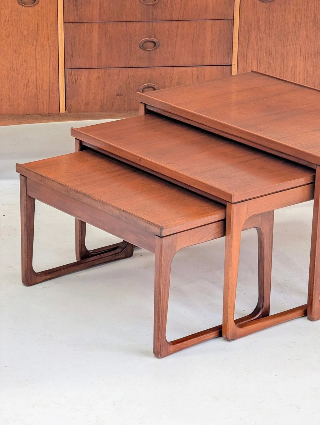 Mid-century teak nesting tables with minimalist design and clean lines, stacked indoors