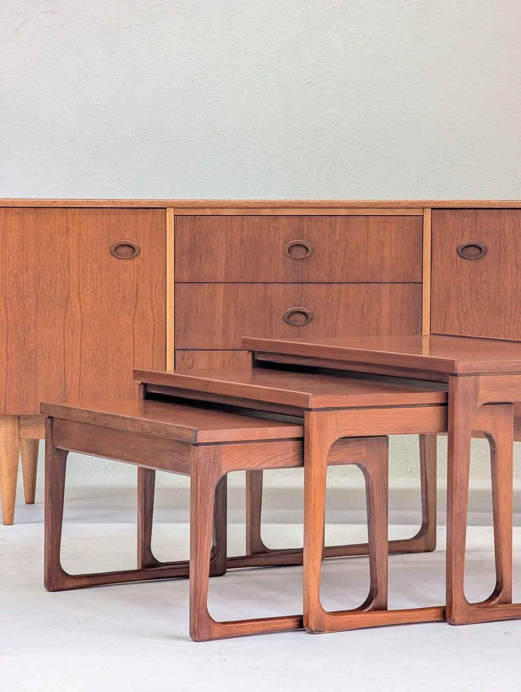Mid-century teak nesting tables in front of matching credenza, vintage 1960s furniture