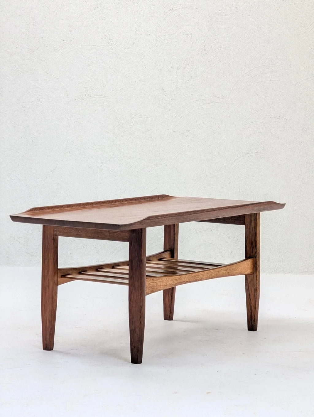Italian solid teak tray top coffee table with slatted shelf on a white background
