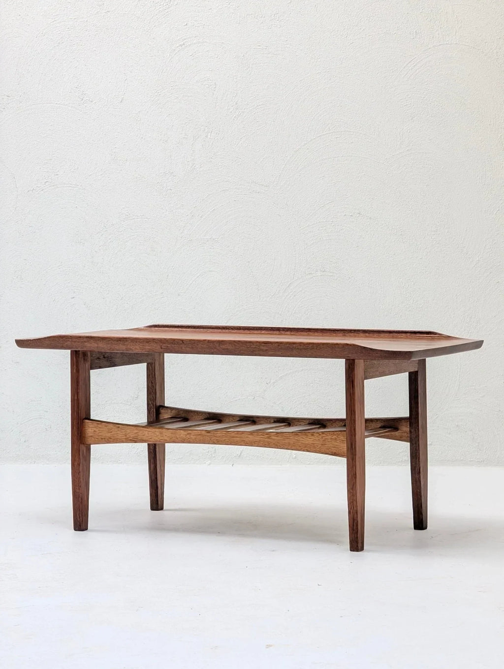 Italian solid teak tray top coffee table with lower slatted shelf on white background