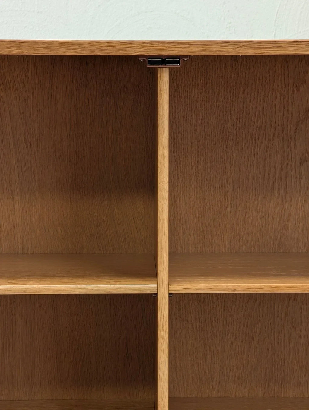 Close-up of oak wood display cabinet interior with shelves and divider, mid-century modern design.
