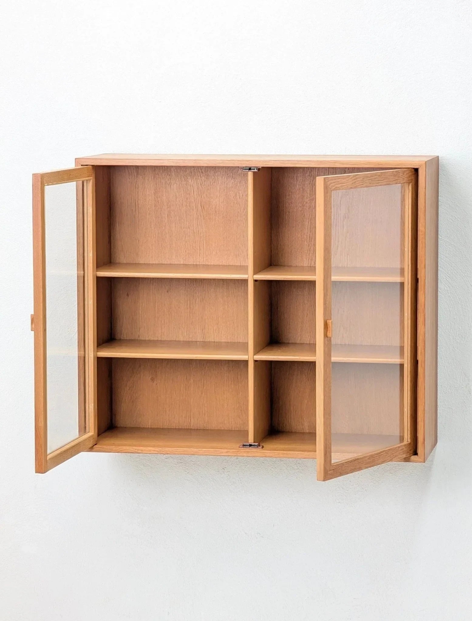 Mid-century oak and glass wall display cabinet with open doors and shelves