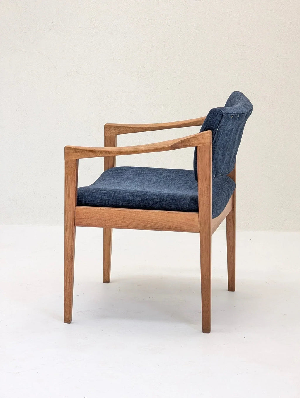 Mid-century modern wooden armchair with blue upholstered seat and backrest