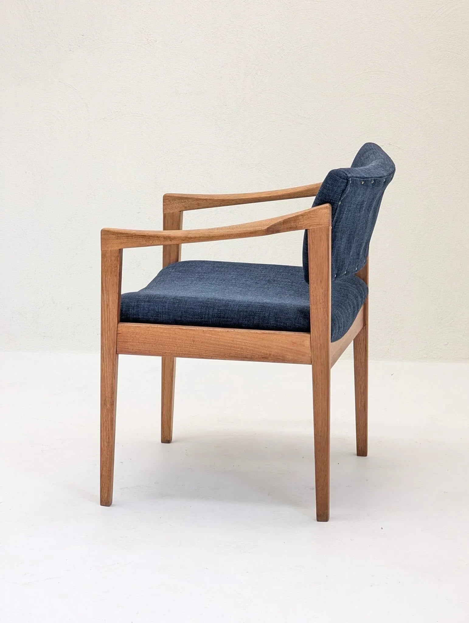 Mid-century modern wooden armchair with blue upholstered seat and backrest