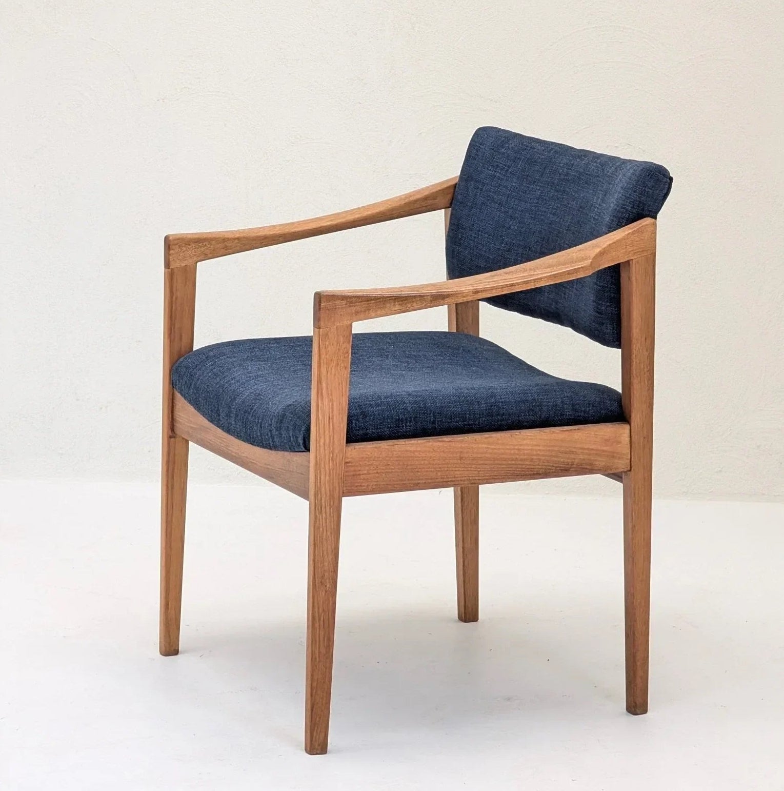 Mid-century modern wooden armchair with navy blue fabric seat and backrest