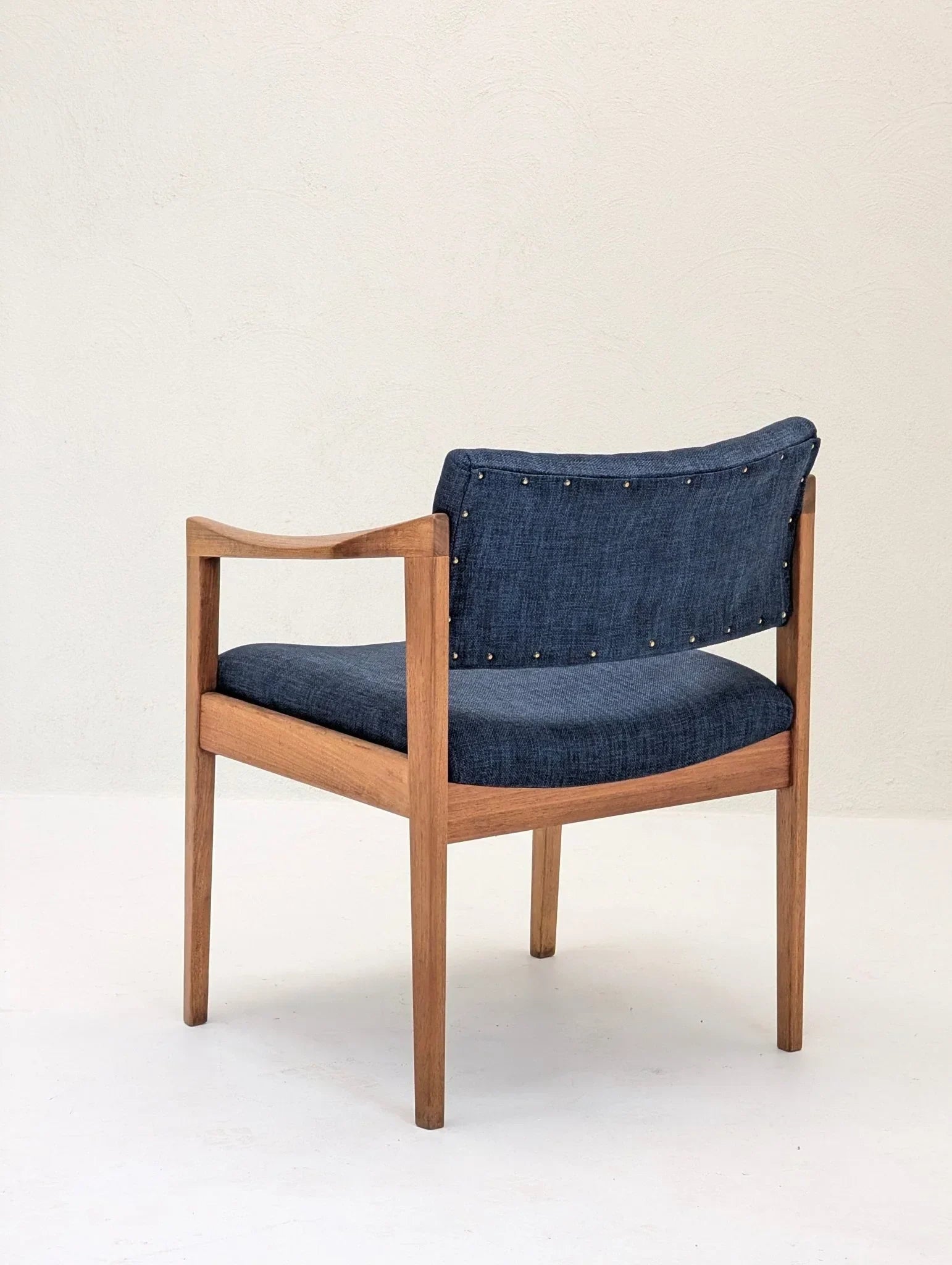 Mid-century modern armchair with wooden frame and blue upholstered seat and backrest
